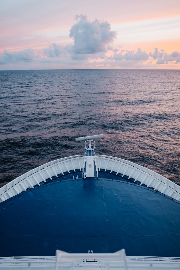 Peaceful ocean horizon captured from a cruise ship deck during tranquil sunset.